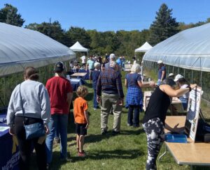 People walk by tables at HarvestFest