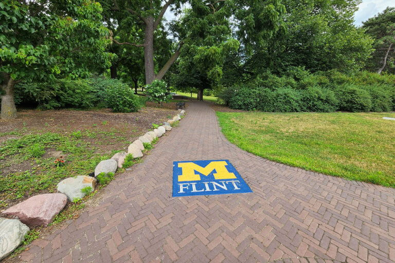 U-M Flint logo on brick pathway