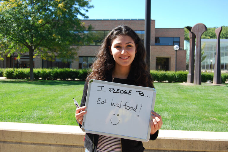 Student holding a sign pledging to eat local food
